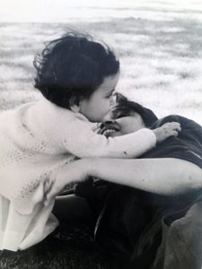 A mother hugs her young daughter.